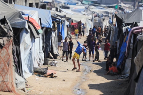 Children play as displaced Palestinians shelter at a camp in Gaza City.