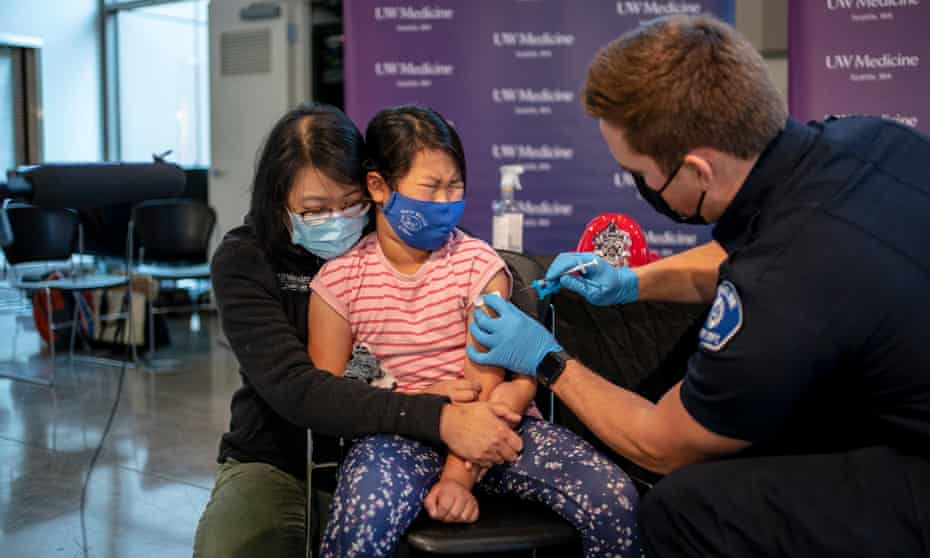 Elise Wong, 7, sits in the lap of her mother as she receives a Covid-19 vaccine in Shoreline, Washington. 
