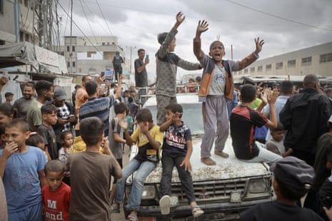 Palestinians, including children, gather in the city of Khan Younis to celebrate after the announcement of a Gaza ceasefire agreement.