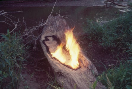 A wood carving laid on the ground with fire coming out of it