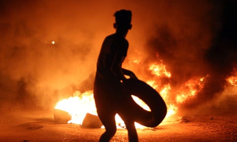 A demonstrator burns tyres during protests last month in the southern Iraqi city of Basra.