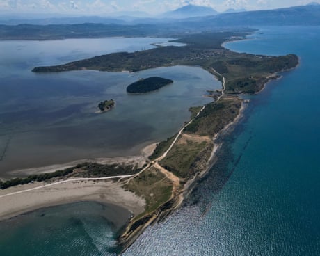 Pamje ajrore e një rripi të gjatë e të hollë toke me gjire ranore në një det të thellë blu.