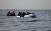 Two dinghies crowded with people wearing lifejackets