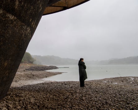 Pippa stands on a rocky shore of Ardingly reservoir, an area normally underwater