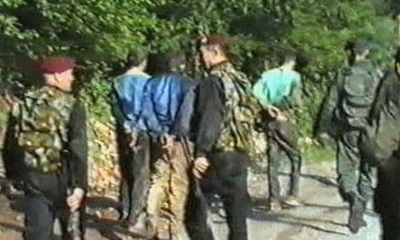 Serbian paramiltaries lead away Bosnian Muslim civilian prisoners who had been taken from Srebrenica.