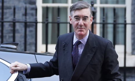 Jacob Rees-Mogg resting a hand on top of an open car door with railings and windows in the background