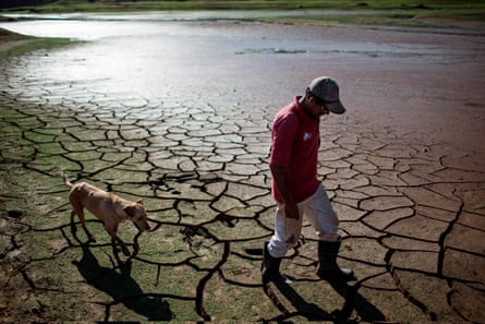 A resident walks his dog across the dry bottom of the Paraibuna dam, part of São Paulo’s Cantareira water system.