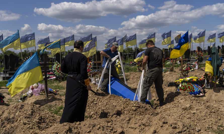 Los enterradores bajan el ataúd del militar ucraniano Oleksander Matyukhin, de 32 años, en Kharkiv, este de Ucrania.