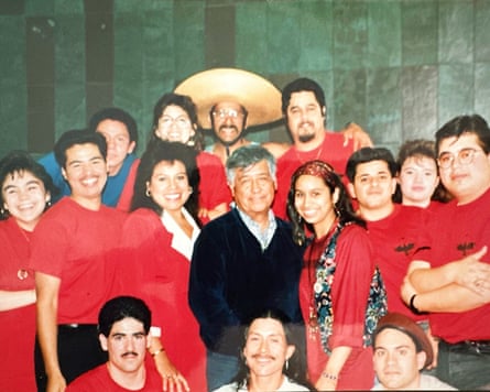 A group of people in red shirts surrounds an older