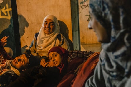 Somar’s sisters, Salsabil and Lubna, leaning on each other as they wait at a bus station.