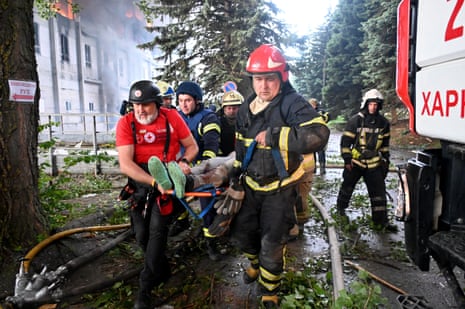 Rescuers carry an injured person out of the ruins of a civilian plant after Russian attacks on Kharkiv early on Saturday.