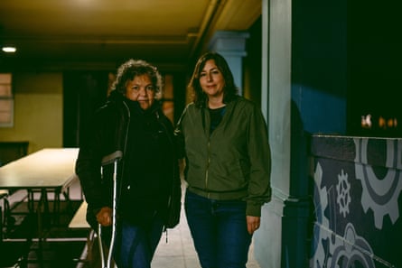 Two woman stand for a portrait on a school campus at night.