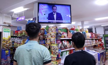 Iranians follow news in a shop in Tehran
