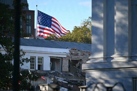 US flag waves above white house with partial demolition
