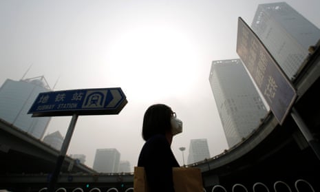 A woman wearing a mask walks in heavy smog in Beijing. Every year about one in 10 babies are born prematurely, according to the WHO.