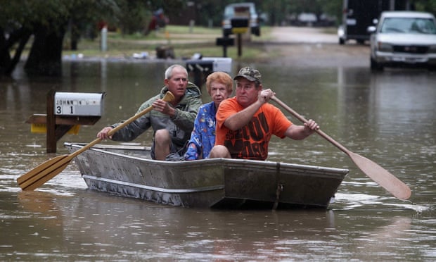Two sons evacuate their mother from her flooded home near Downsville, Texas.