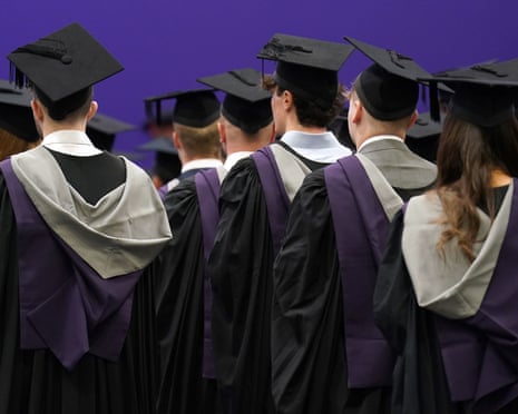 A group of graduating students in cloaks and mortarboards photographed from behind