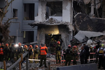 Emergency workers by a damaged building.