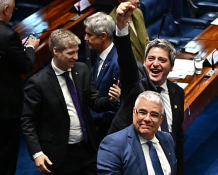 Opposition senators smile and one raises a fist into the air in the senate