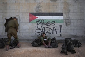 A soldier reads next to mock Palestinian graffiti