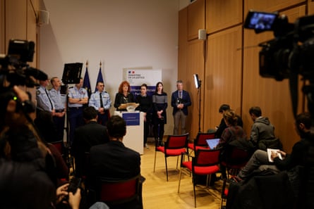 A woman, surrounded by people, talks into a microphone