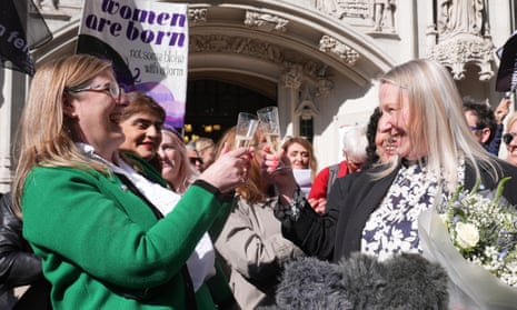 Women smile and raise glasses in front of the UK supreme court building