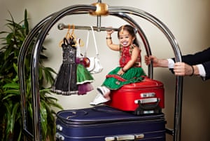 Jyoti Amge, who is tiny, sitting on a suitcase