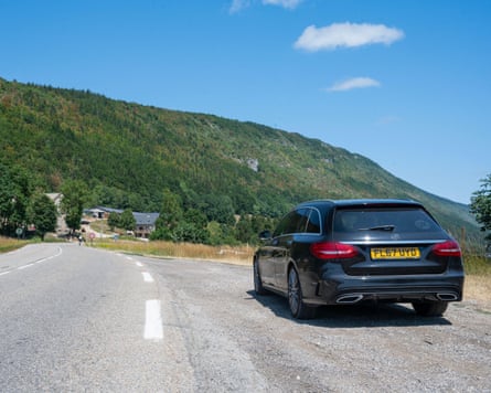 Car driving on a French mountain road in the Alps
