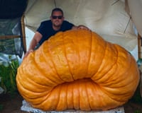 Man stands behind huge pumpkin
