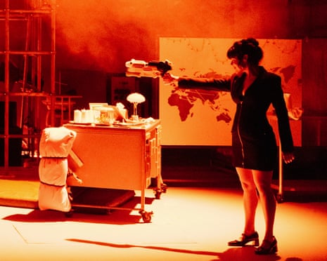 A woman stood on a red-lit stage holding a plastic fake space gun.