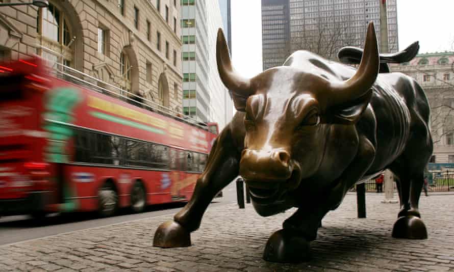 A tour bus passes the Wall Street bull.