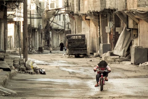 A Syrian girl rides her bicycle in an almost deserted street in Damascus in 2013