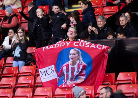A fan holds up a banner commemorating the former Sheffield United player Maddy Cusack.