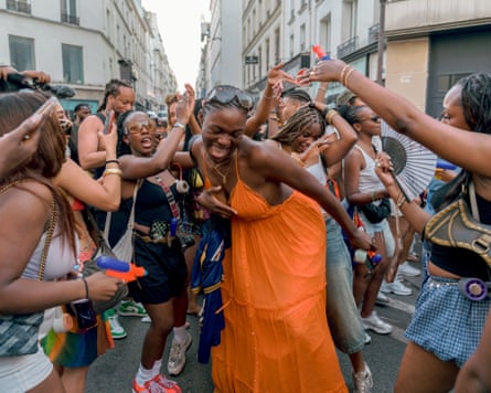 Group of women dancing with toy water guns in a crowded street during Fete de la Musique in Paris, Ile-de-France, France