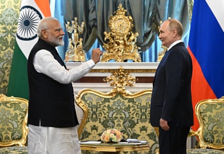 The two men facing each other in an ornate room, standing in front of Indian and Russian flags