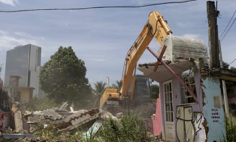 An excavator works to demolish a house in the Vila Autodromo slum in Rio de Janeiro.