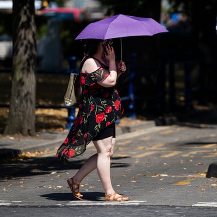 A woman using a brolly to keep cool in Boston town centre.