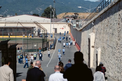 people walk down path along wall