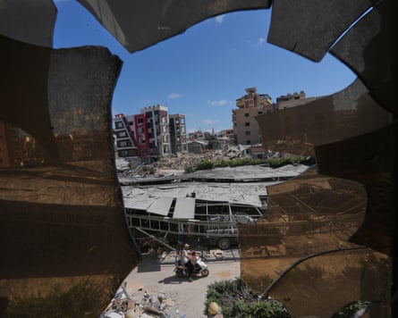 Buildings damaged by Israeli strikes are seen through shattered glass from the Jabal Amel Hospital in Tyre, Lebanon on 18 June 2026.