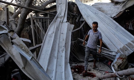 A man inspects his destroyed home after an Israeli airstrike on Gaza City