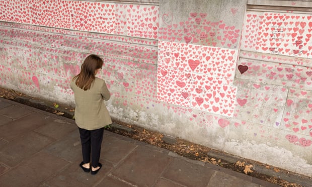 A woman pauses to look at the hearts and personal tributes to some of those lost to Covid-19 in London.