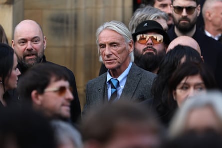 Paul Weller in crowd of people at the funeral