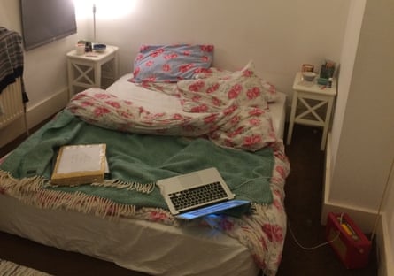 An open laptop on an unmade bed