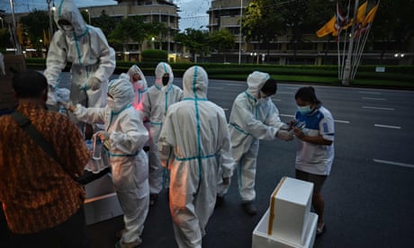 THAILAND-HEALTH-VIRUS<br>Homeless and low-income residents receive daily food donations from volunteers wearing protecive gear near Democracy Monument amid Covid-19 coronavirus pandemic in Bangkok on July 16, 2021. (Photo by Lillian SUWANRUMPHA / AFP) (Photo by LILLIAN SUWANRUMPHA/AFP via Getty Images)