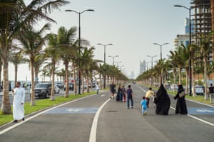 Families walk along the north corniche beach area