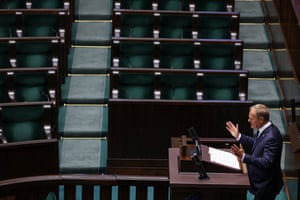The Polish prime minister, Donald Tusk, speaks in parliament flanked by empty seats of the Law and Justice (PiS) opposition party