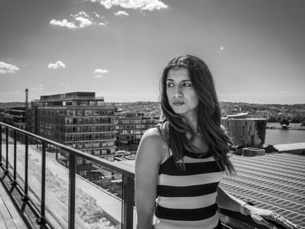 A woman on a rooftop overlooking a cityscape.