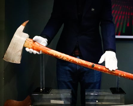 A person in white gloves holding a large axe