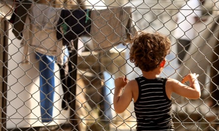 A child looks through a fence at the Moria refugee camp on the Greek island of Lesbos