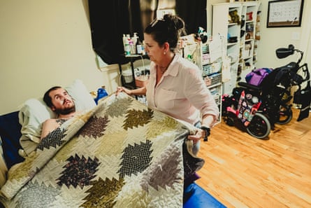 A mother tucks her son into bed